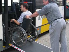 rolstoelgebruiker rijdt de bus binnen via de oprijplaat