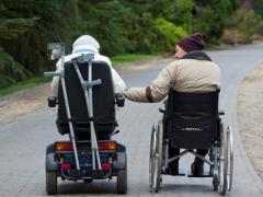 twee rolstoelgebruikers zijn samen op pad